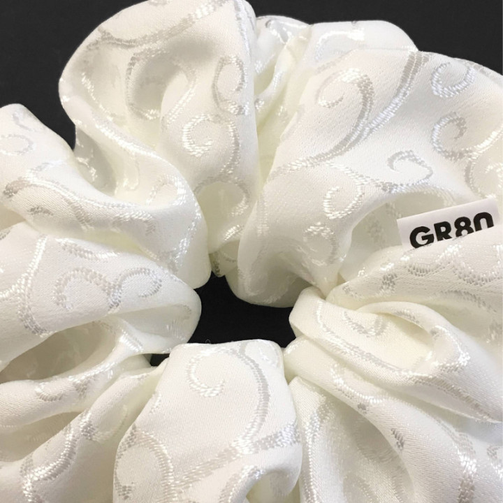 Óriás, inda mintával hímzett hajgumi (scrunchie) prémium minőségű anyagból. Átmérője kb. 16-17 cm. Törtfehér szín