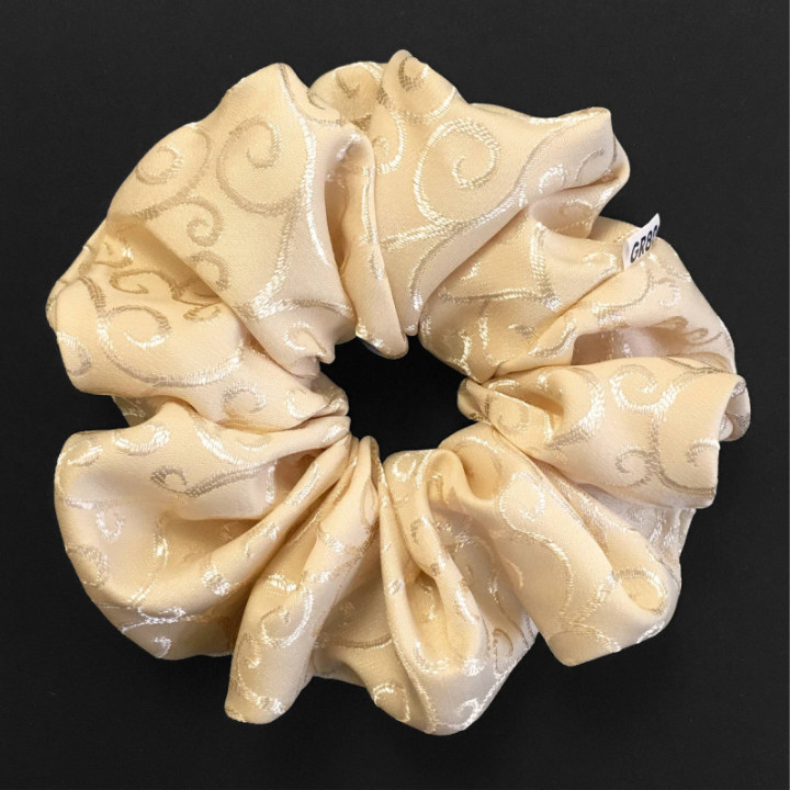 Óriás, inda mintával hímzett hajgumi (scrunchie) prémium minőségű anyagból. Átmérője kb. 16-17 cm. Ekrü/bézs szín